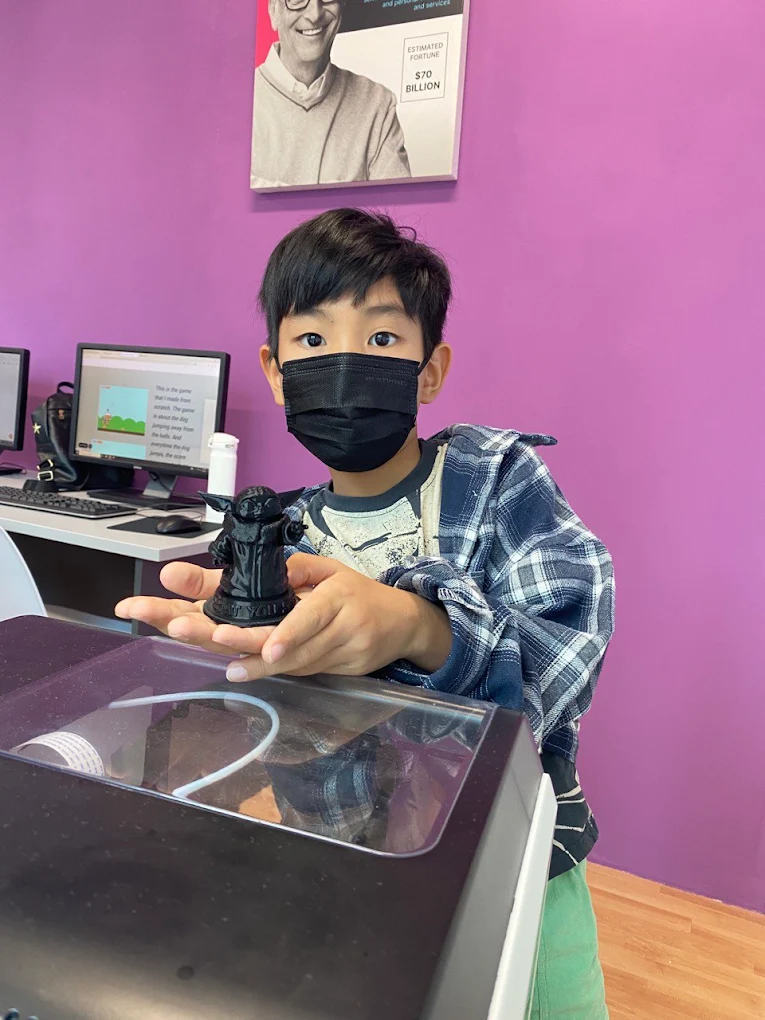 A student holding a 3D-printed figure he designed